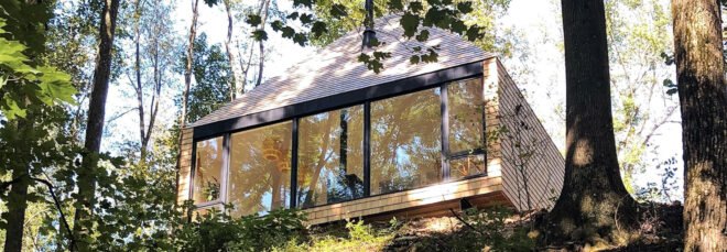 wood cabin perched on cliff in a forest