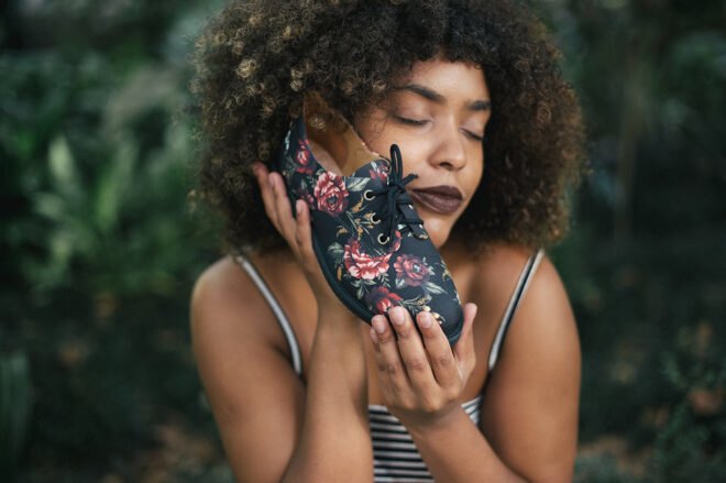 person holding a vegan shoe with a floral print