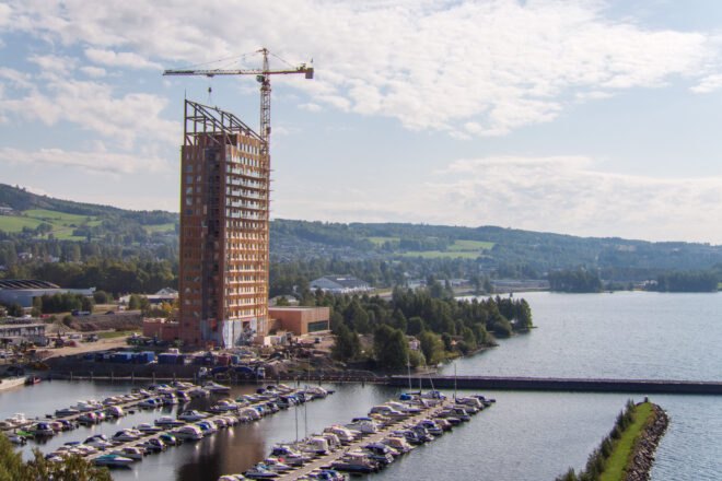 crane adding parts to unfinished wood building
