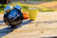 black alarm clock sits on wooden table next to yellow coffee cup