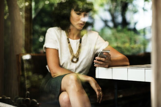 woman with fashionable clothing looking at her phone