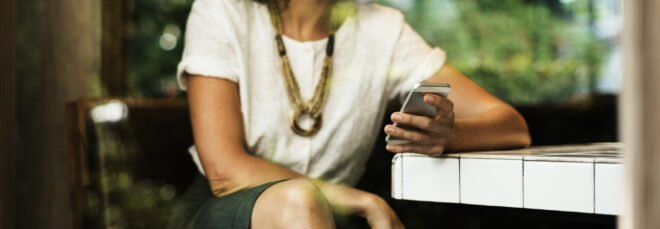 woman with fashionable clothing looking at her phone