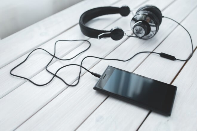 smartphone and headphones on white table