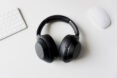 black headphones, white computer mouse and white keyboard on white table