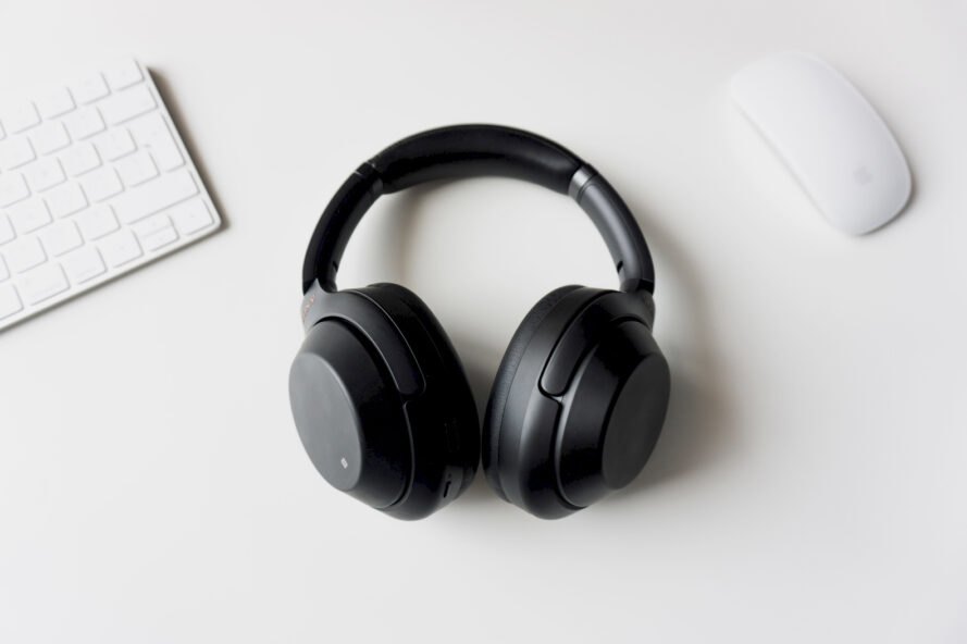 black headphones, white computer mouse and white keyboard on white table