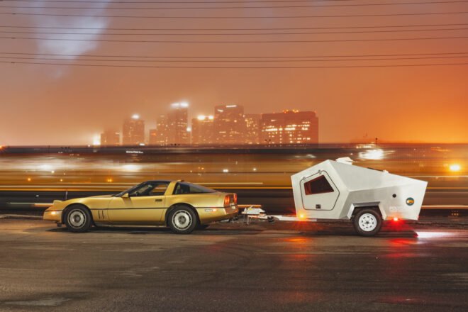 small car pulling metal geometric travel trailer