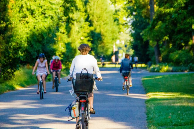 woman rides bike with briefcase in back basket