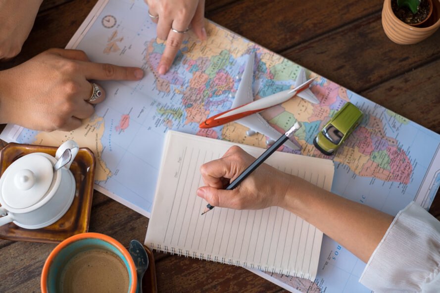people plan out vacation with map and notes
