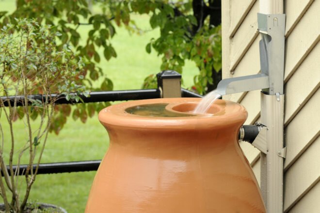 rain coming from spout into a barrel