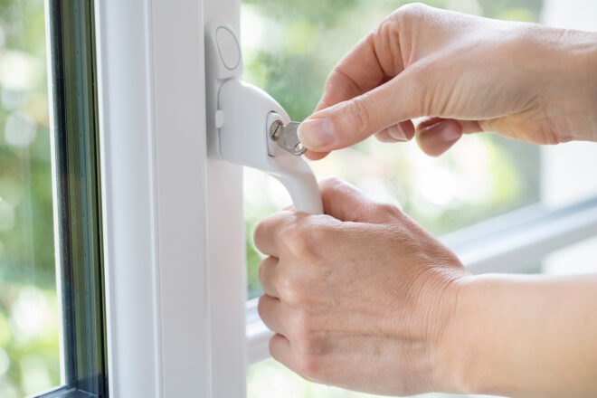 person locking a window lock