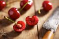 cherries with pits on a cutting board
