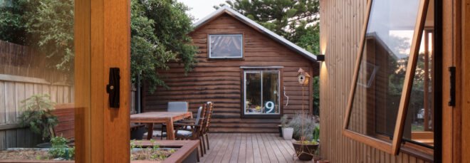wood deck leading to wood building with gabled roof