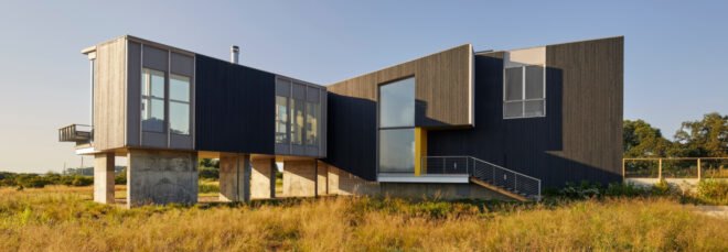 modern home sitting above expansive marshland