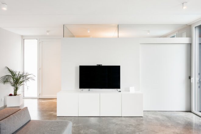 all white living space with tv on white consol