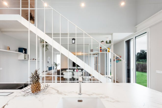 all white living area with steel staircase