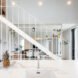 all white living area with steel staircase