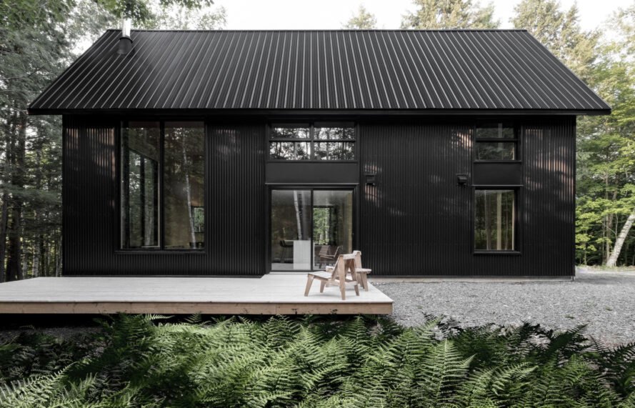 black cabin with wooden deck