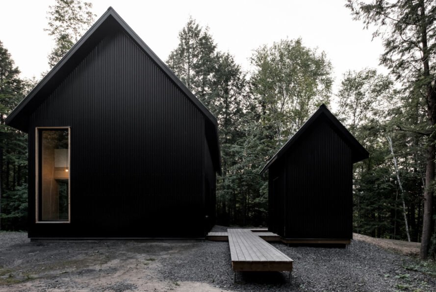 two black cabins with pitched roofs