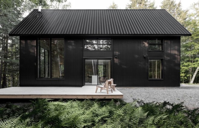 black cabin with wooden deck