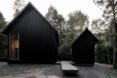 two black cabins with pitched roofs