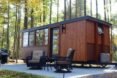wooden tiny home with concrete deck and seating area