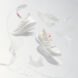 white recycled running shoes on display with white background