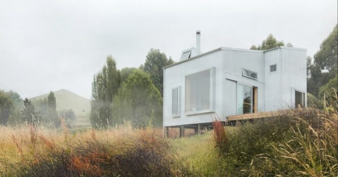 tiny cabin clad in corrugated metal with large window