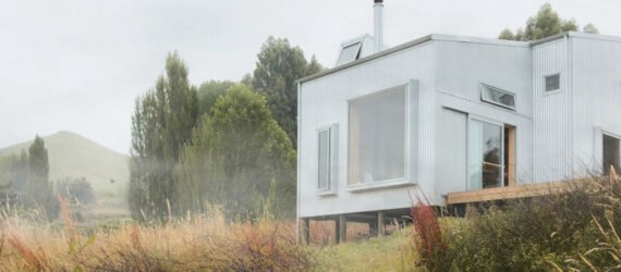 tiny cabin clad in corrugated metal with large window