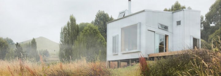 tiny cabin clad in corrugated metal with large window
