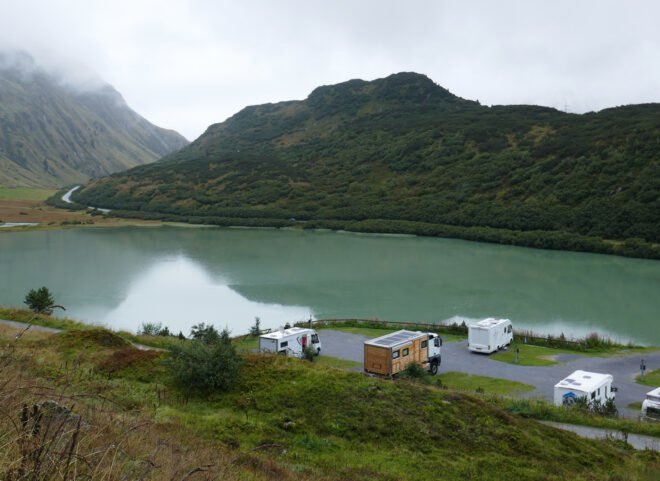 wooden RV at the edge of a large lake