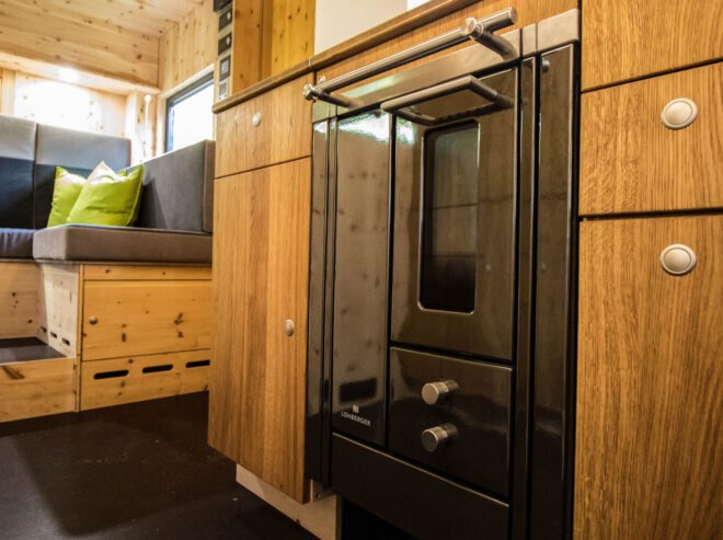 black oven surrounded by wooden cabinetry