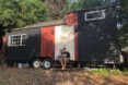 couple sitting in front of their tiny home