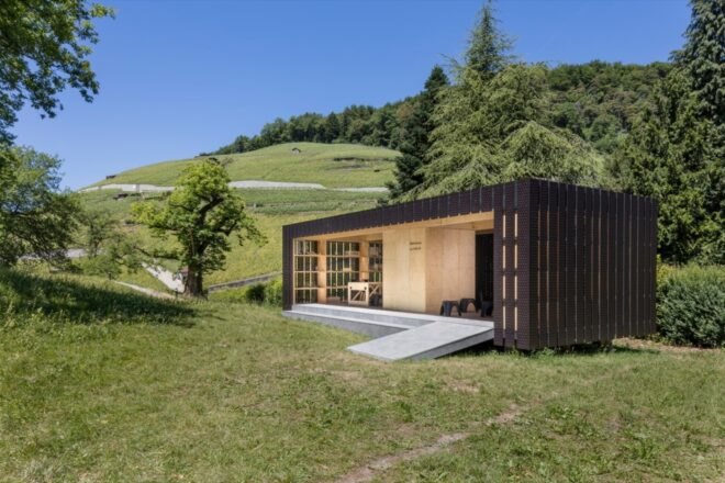 small prefabricated pop up pavilion is surrounded by trees and greenery