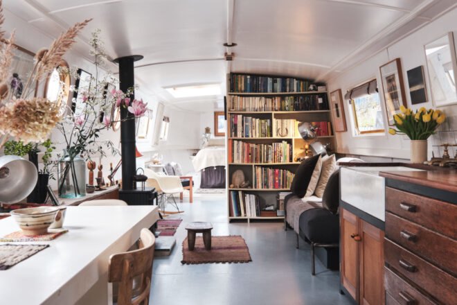 large living space with bookcases and kitchen