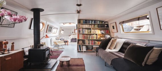 large living space with bookcases and kitchen