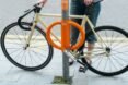 bike locked to street pole with orange lock