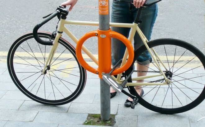 bike locked to street pole with orange lock