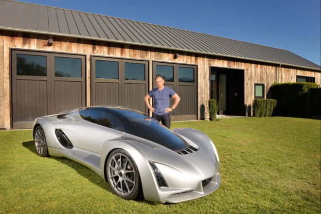 man standing next to a 3d printed silver car