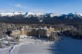 hotel with mountains in the background surrounded by trees and snow