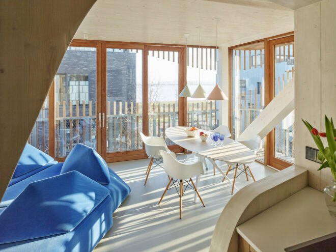 room with tall glass walls and blue geometric couch