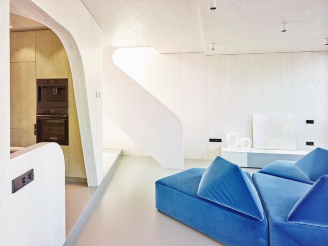 interior space with all white walls and blue sofa