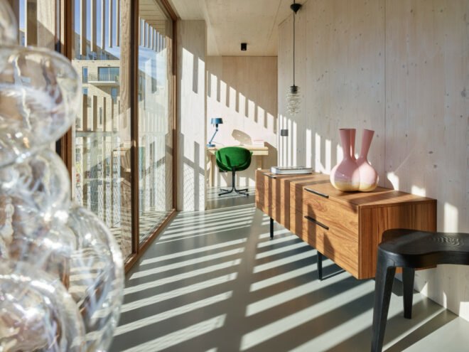 wood cabinets and art in a room with a glass wall