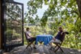 two people sitting at round table on treehouse deck