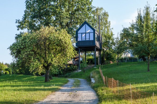 black treehouse with many windows