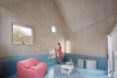 wood-lined interior with blue floors and pink sofa