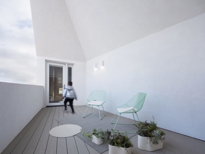 wooden outdoor deck attached to a white home