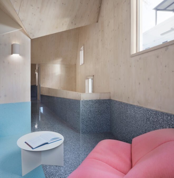 wood-lined interior with pink sofa on blue floor