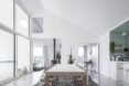 large wood table in dining room surrounded by white walls and minimalist designs and plants