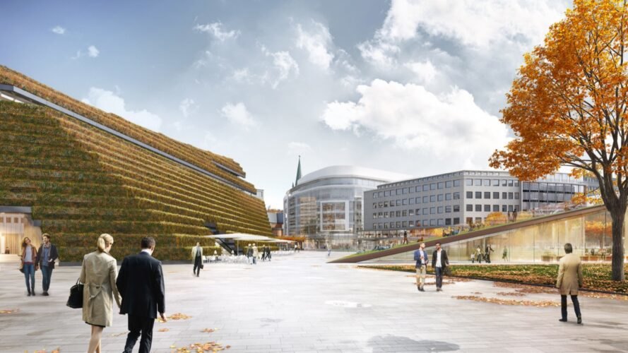 trapezoid-shaped building with sloping green roof turning orange in the fall