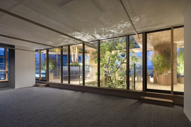office with glass walls surrounded by plants